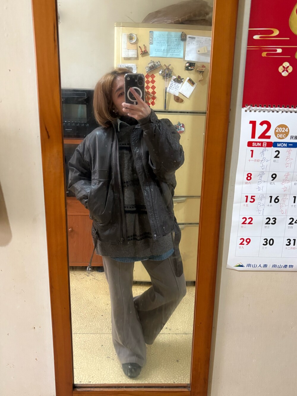 グレー系のニット/セーター、グレー系のチノパンツ、ブラウン系のその他アウターを着用したレディースの冬コーディネートの2枚目の写真