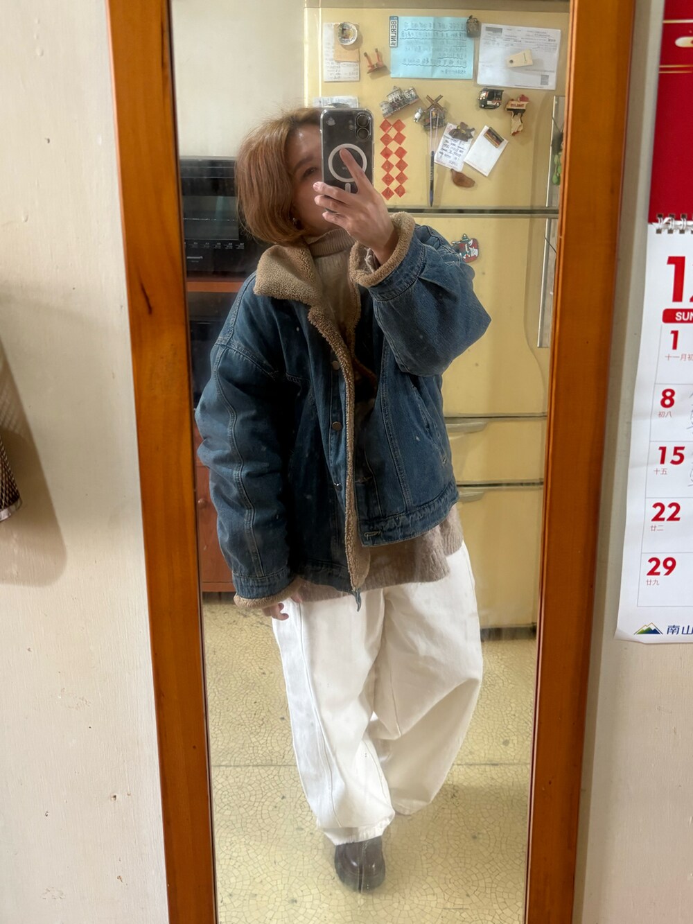 ベージュ系のニット/セーター、ブルー系のデニムジャケット、ベージュ系のチノパンツを着用したレディースの冬コーディネートの2枚目の写真