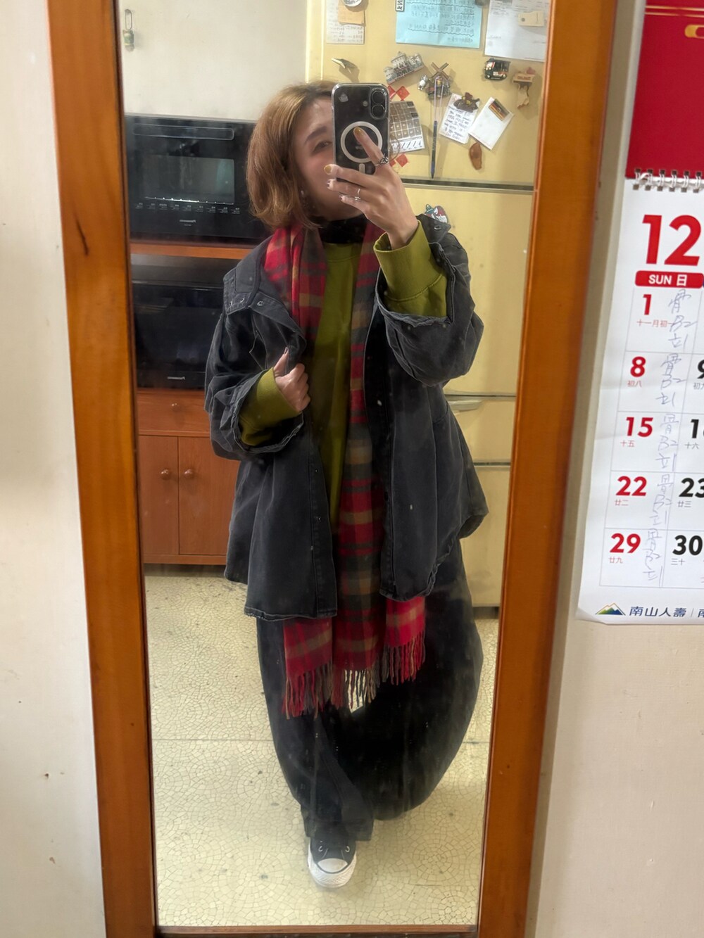 イエロー系のスウェット、ブラック系のデニムジャケット、ブラック系のデニムパンツを着用したレディースの冬コーディネートの2枚目の写真