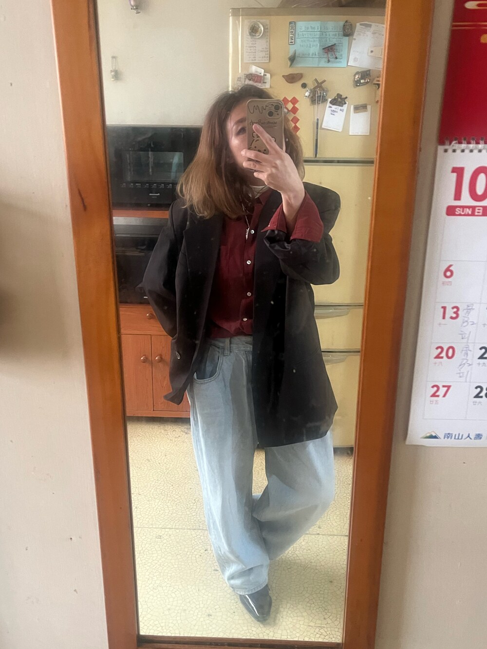 ブラウン系のテーラードジャケット、ブルー系のデニムパンツ、ブラック系のその他シューズを着用したレディースの秋コーディネートの2枚目の写真