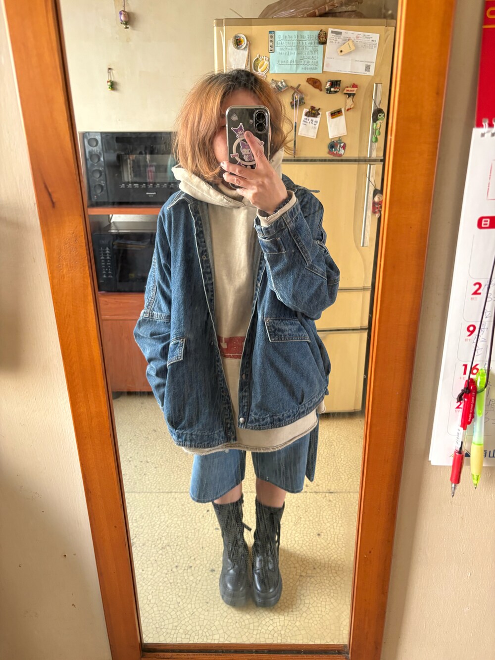 ベージュ系のスウェット、ブルー系のデニムジャケット、ブルー系のカーゴパンツを着用したレディースの春コーディネートの2枚目の写真