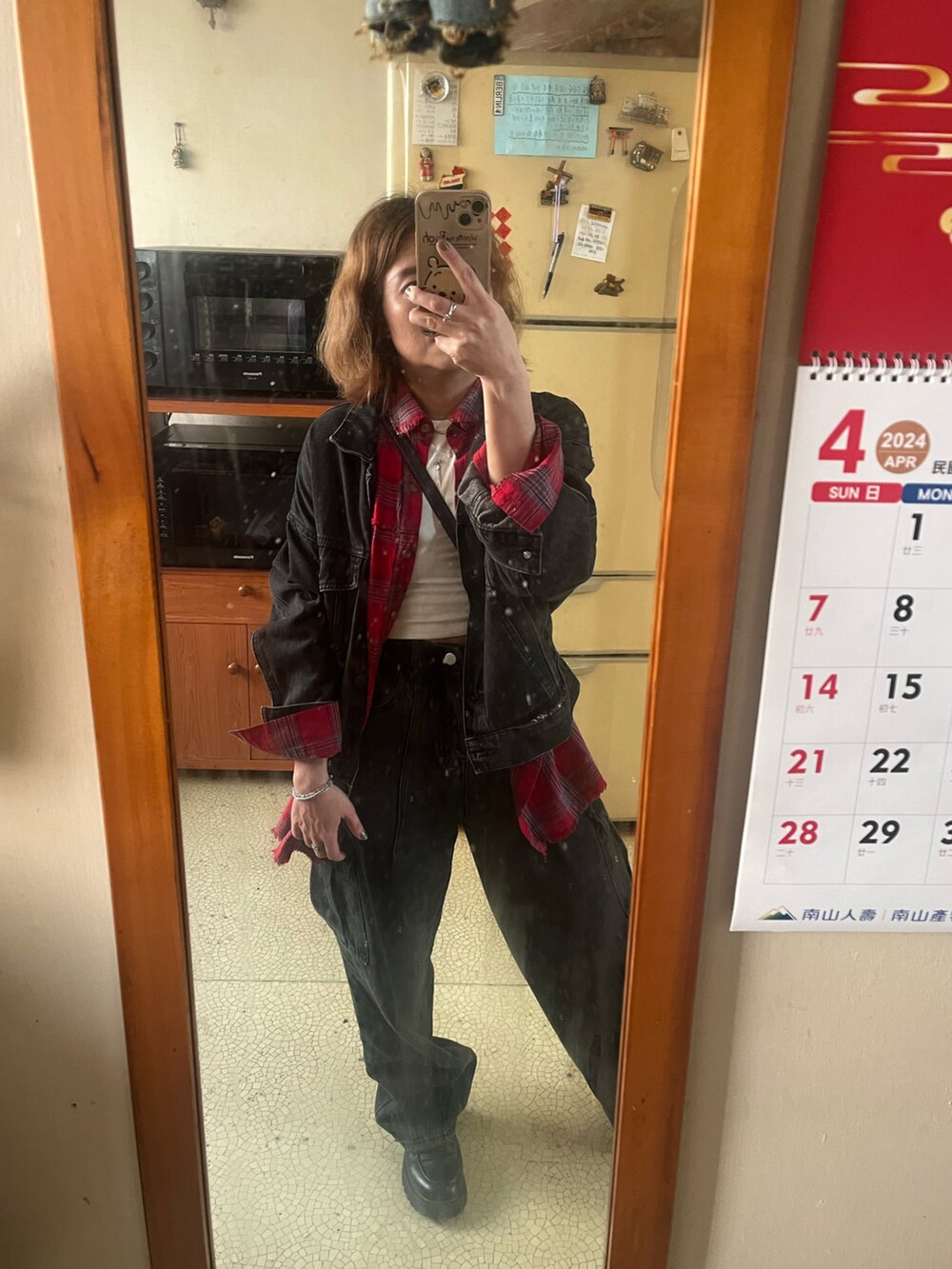 レッド系のシャツ/ブラウス、ブラック系のデニムジャケット、グリーン系のライダースジャケットを着用したレディースの春コーディネートの2枚目の写真