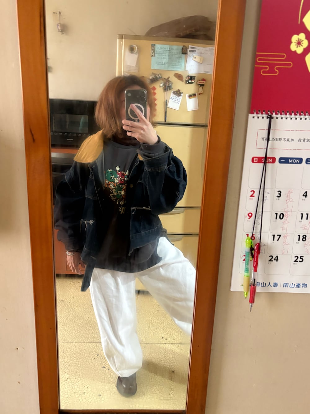 グレー系のスウェット、ホワイト系のチノパンツ、ブラウン系のブーツを着用したレディースの冬コーディネートの2枚目の写真