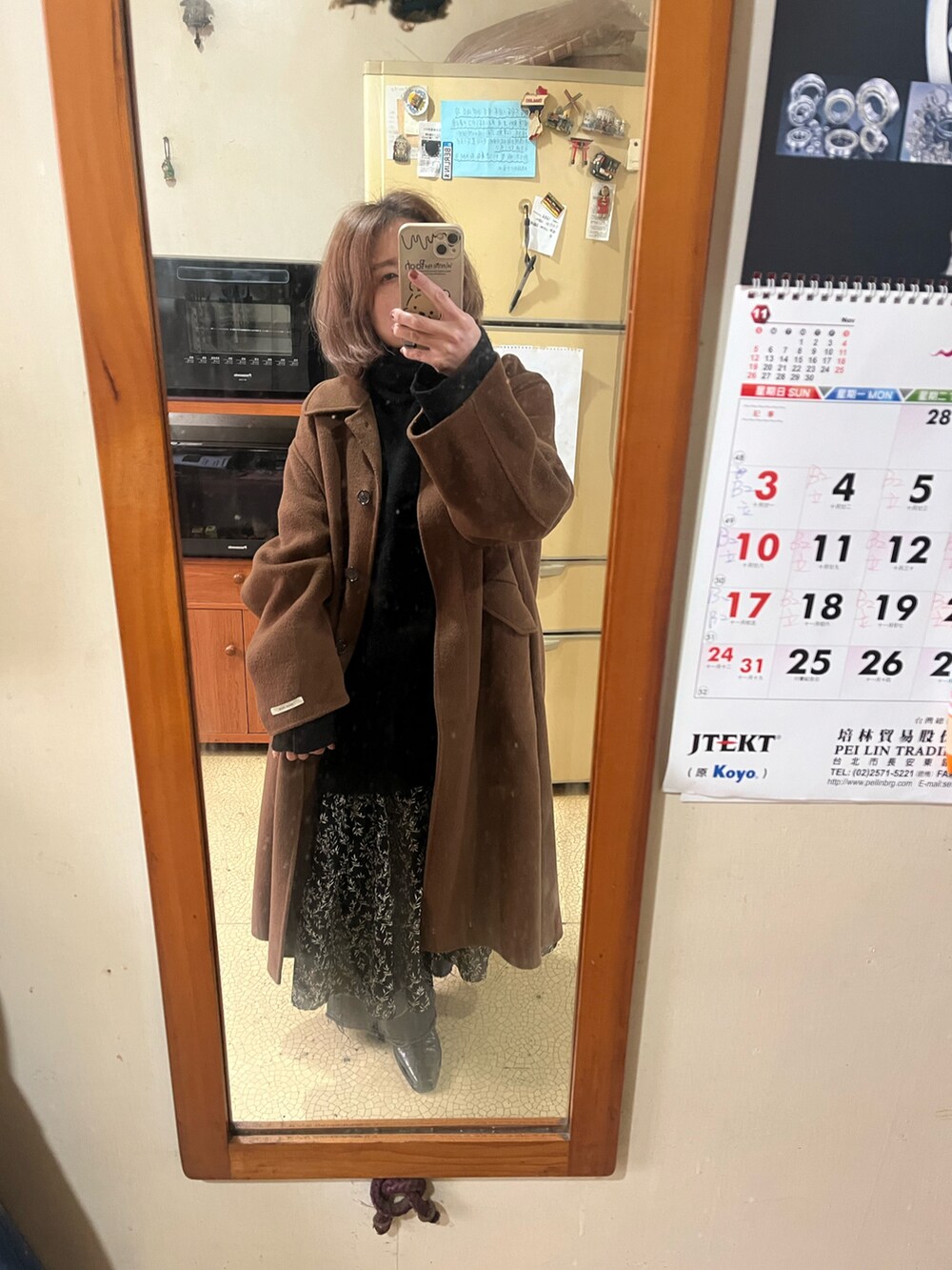 ブラック系のニット/セーター、ブラック系のワンピース、ブラウン系のダッフルコートを着用したレディースの冬コーディネートの2枚目の写真