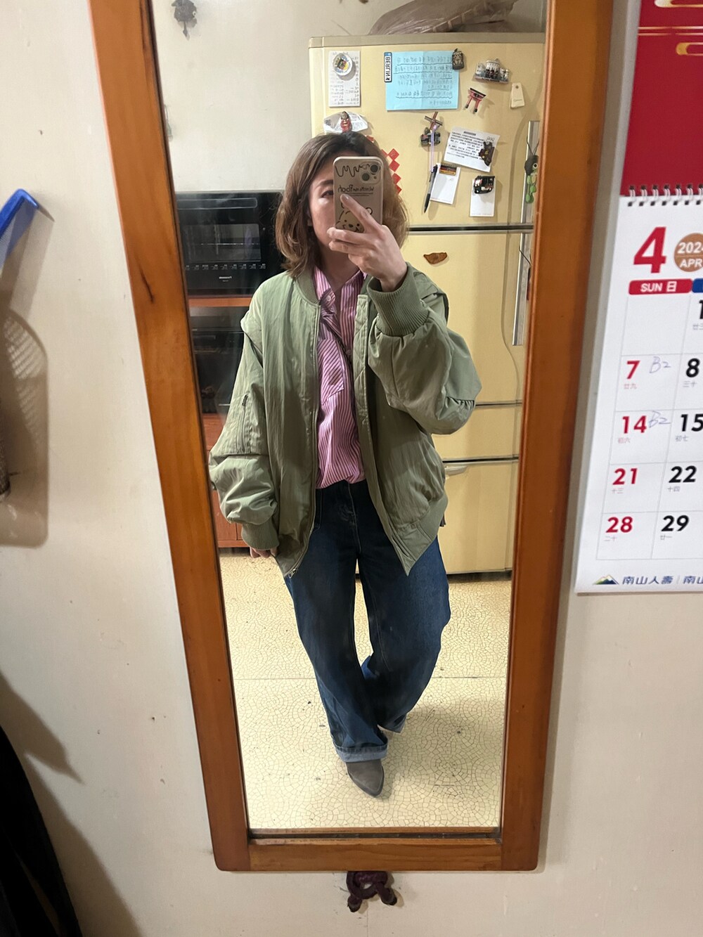 ピンク系のシャツ/ブラウス、グリーン系のマウンテンパーカー、その他のショルダーバッグを着用したレディースの春コーディネートの2枚目の写真