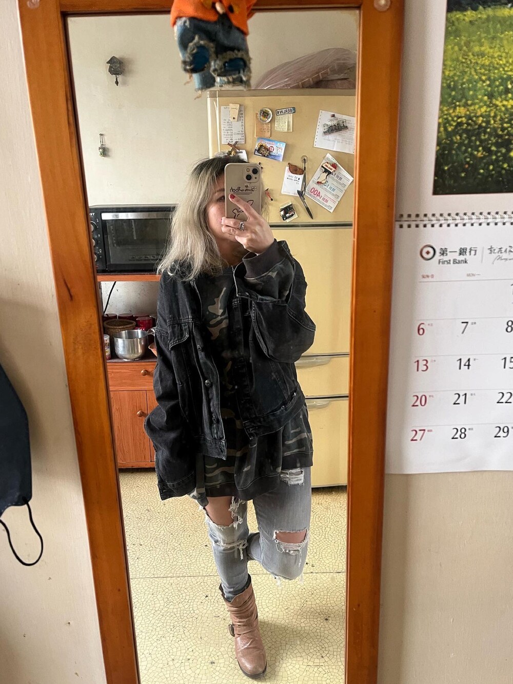 グリーン系のスウェット、グレー系のデニムパンツ、ブラック系のデニムジャケットを着用したレディースの秋コーディネートの2枚目の写真