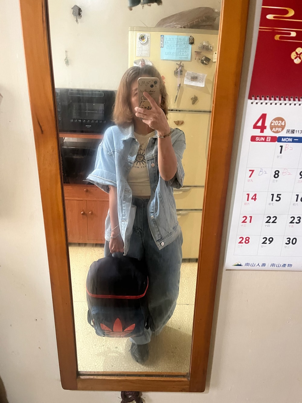 ブルー系のデニムジャケット、ベージュ系のタンクトップ、ブルー系のデニムパンツを着用したレディースの春コーディネートの2枚目の写真