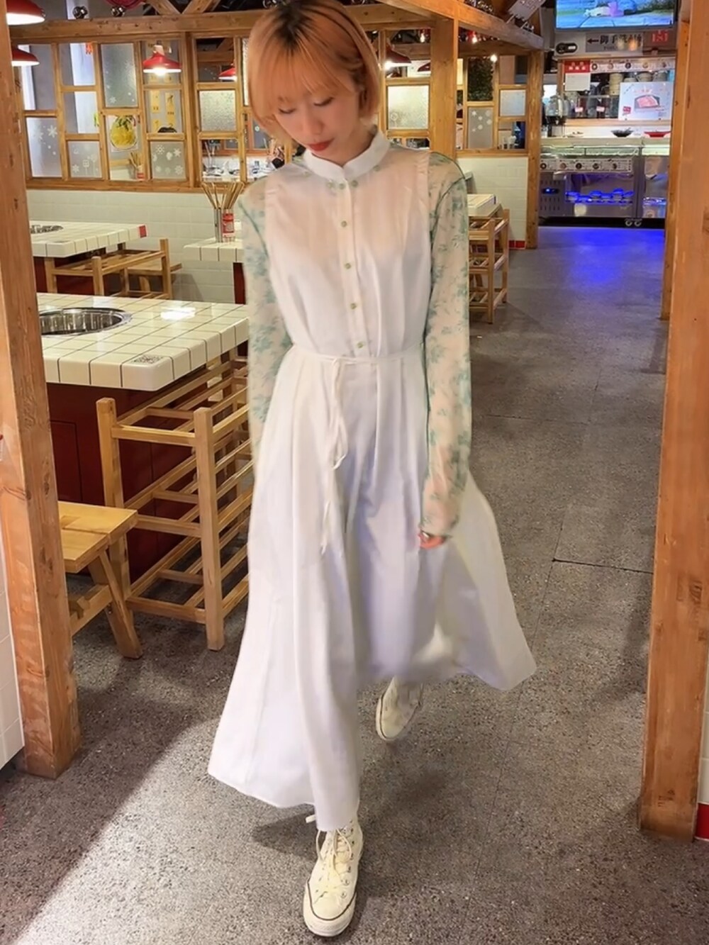 ホワイト系のワンピース、グリーン系のトップス、ホワイト系のスニーカーを着用したレディースの冬コーディネートの3枚目の写真