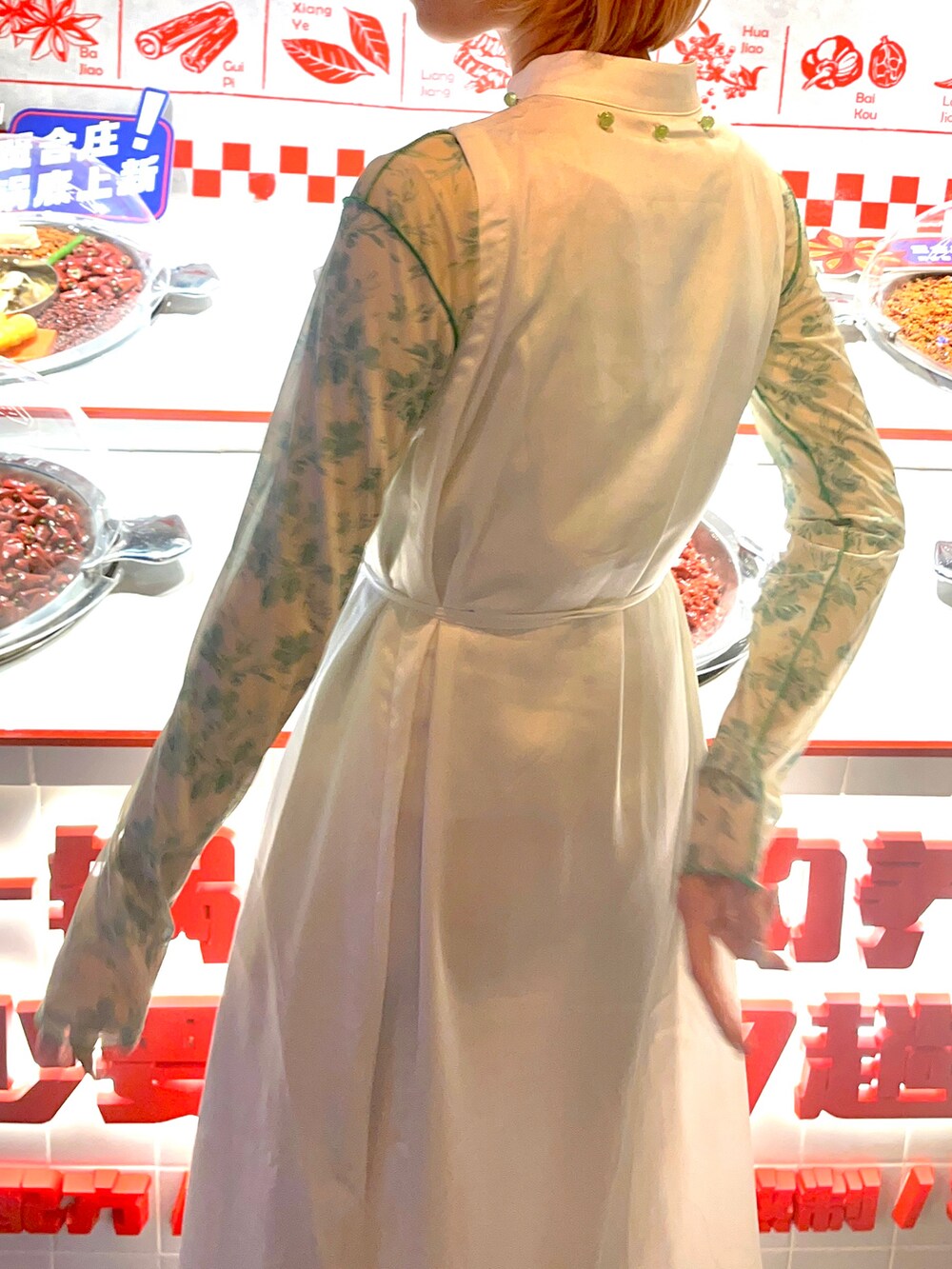 ホワイト系のワンピース、グリーン系のトップス、ホワイト系のスニーカーを着用したレディースの冬コーディネートの2枚目の写真