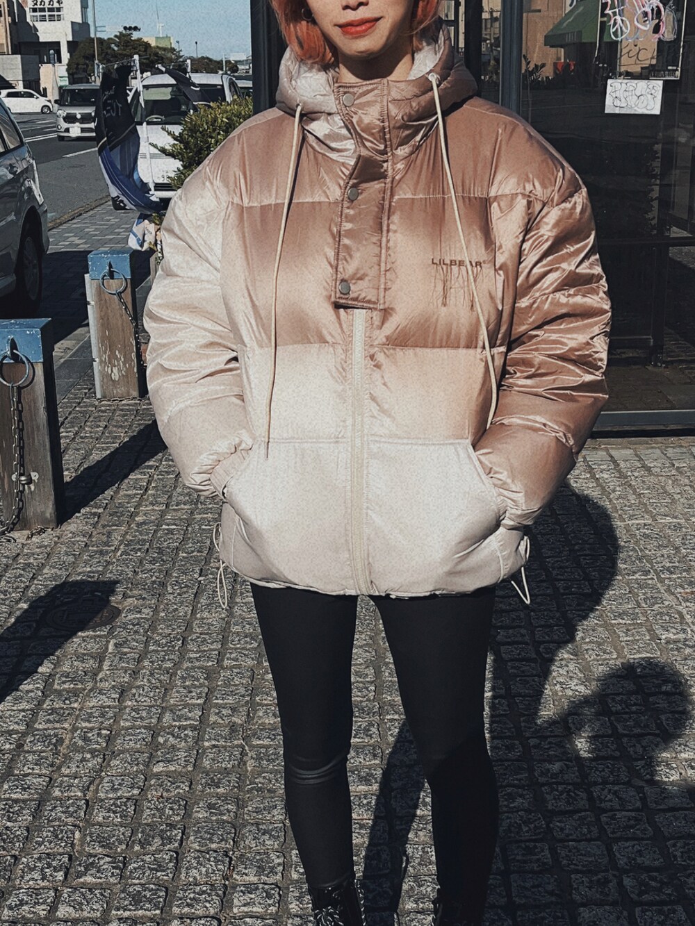 ベージュ系のダウンジャケット/コート、ブラック系のブーツを着用したレディースの冬コーディネートの2枚目の写真