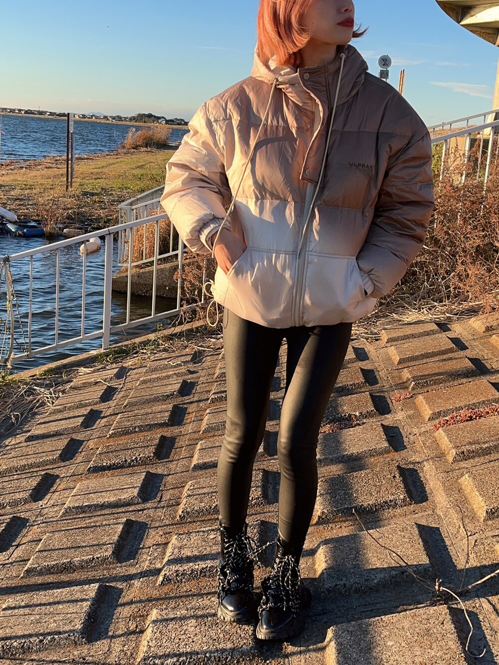 ベージュ系のダウンジャケット/コート、ブラック系のブーツを着用したレディースの冬コーディネートの3枚目の写真