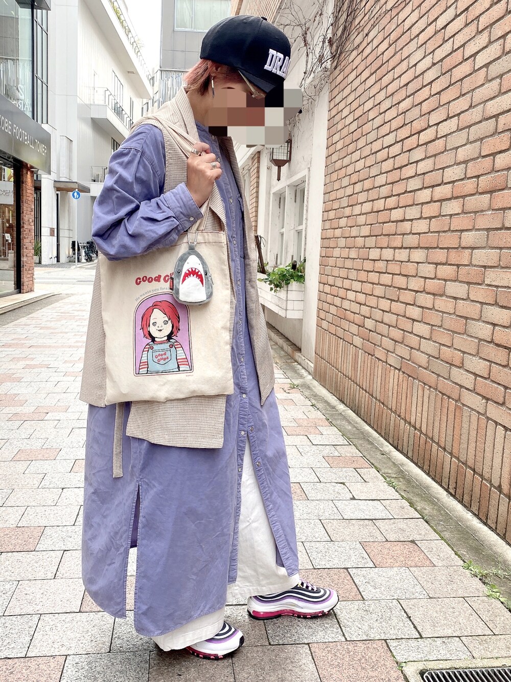 パープル系のスニーカー、ブルー系のシャツワンピース、ベージュ系のベストを着用したレディースの秋コーディネートの2枚目の写真