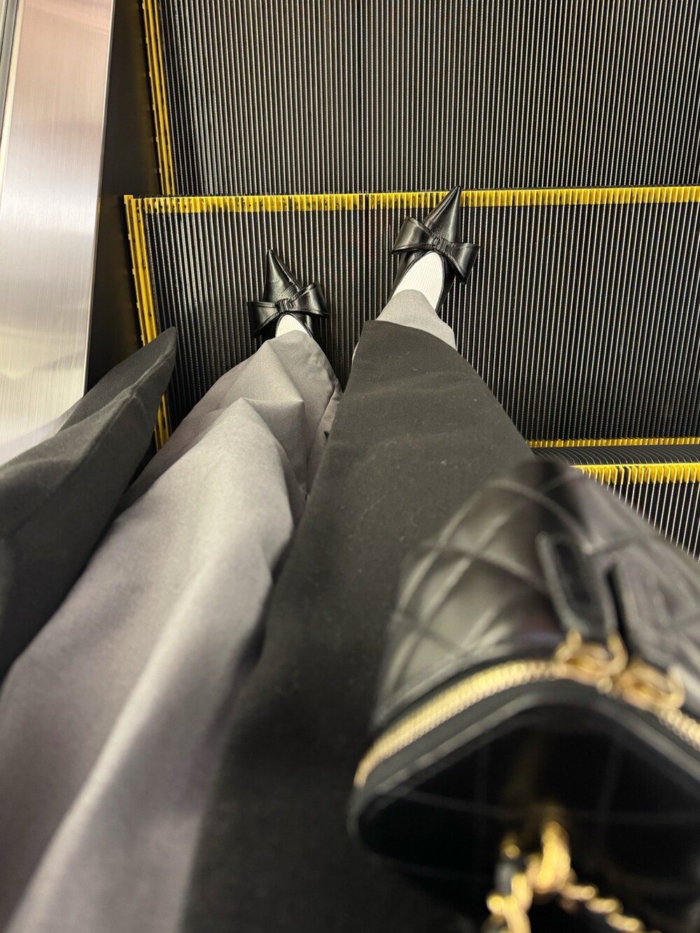 グレー系のその他パンツ、ブラック系のショルダーバッグ、ホワイト系のニット/セーターを着用したレディースの冬コーディネートの2枚目の写真