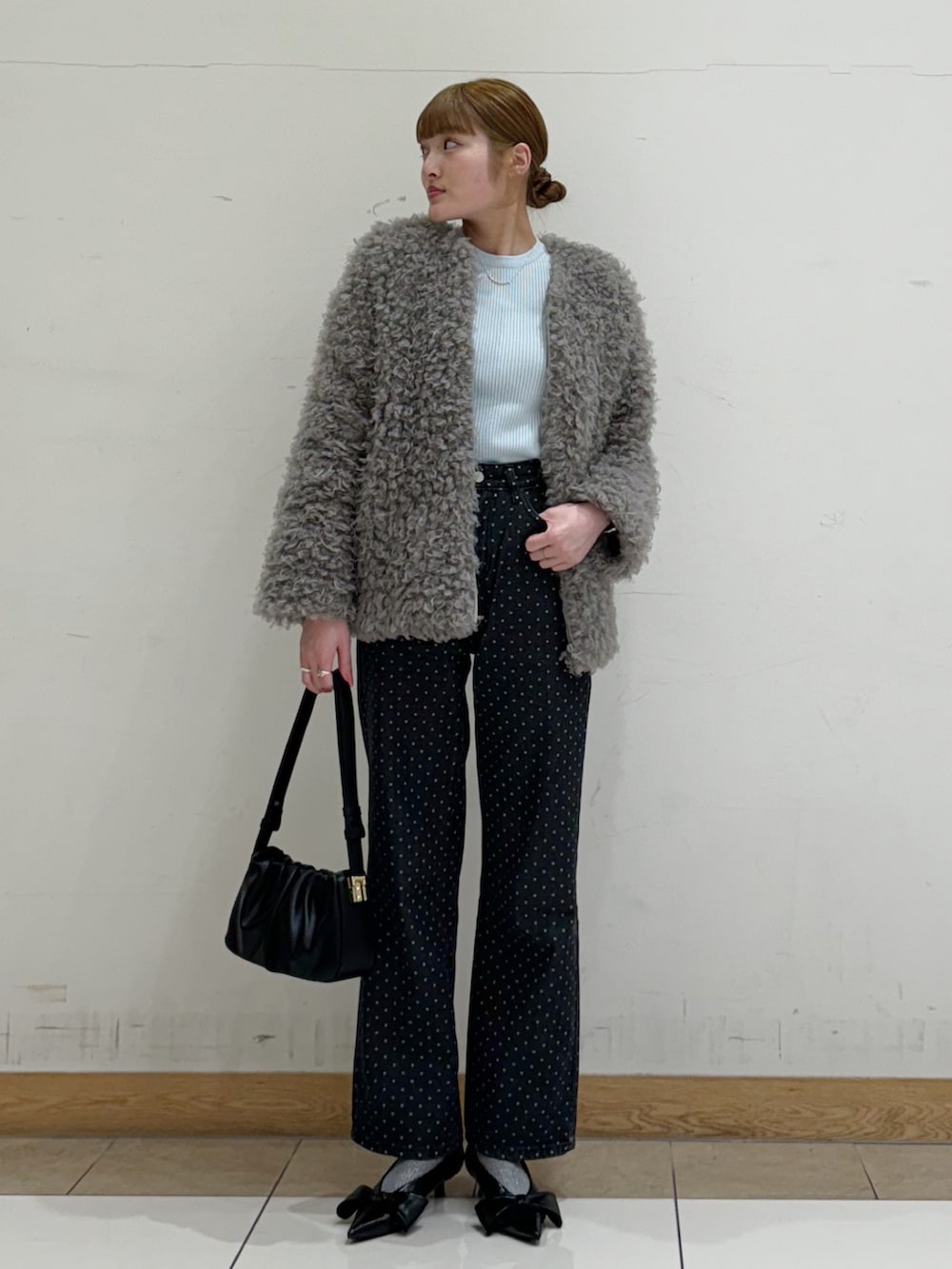 ブラック系のショルダーバッグ、ブラック系のデニムパンツ、ブラック系のパンプスを着用したレディースの春コーディネートの2枚目の写真