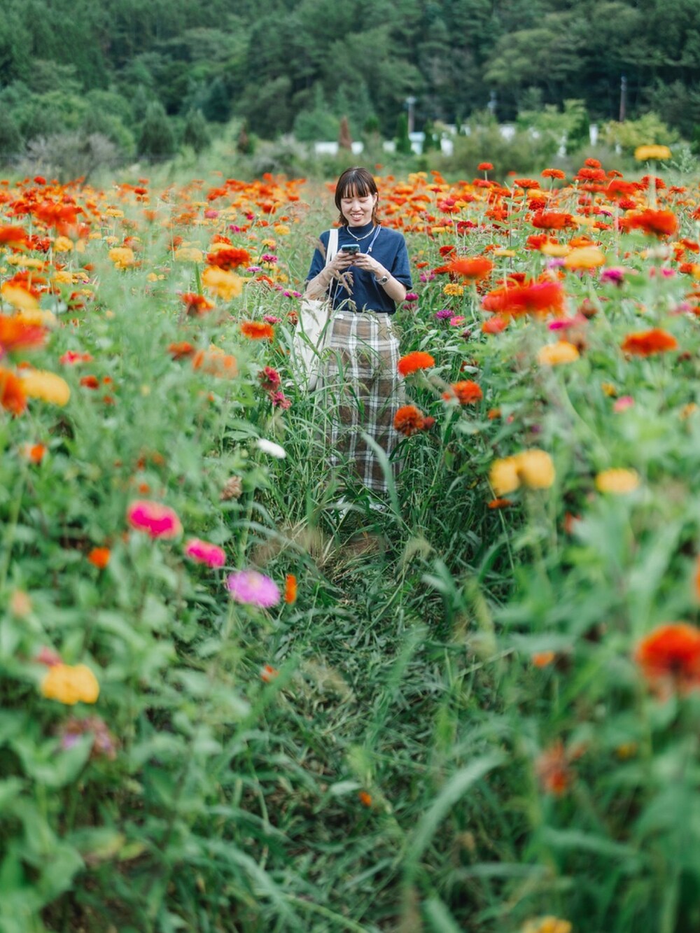 ベージュ系のスカート、ブルー系のTシャツ/カットソー、ホワイト系のサンダルを着用したレディースの秋コーディネートの2枚目の写真