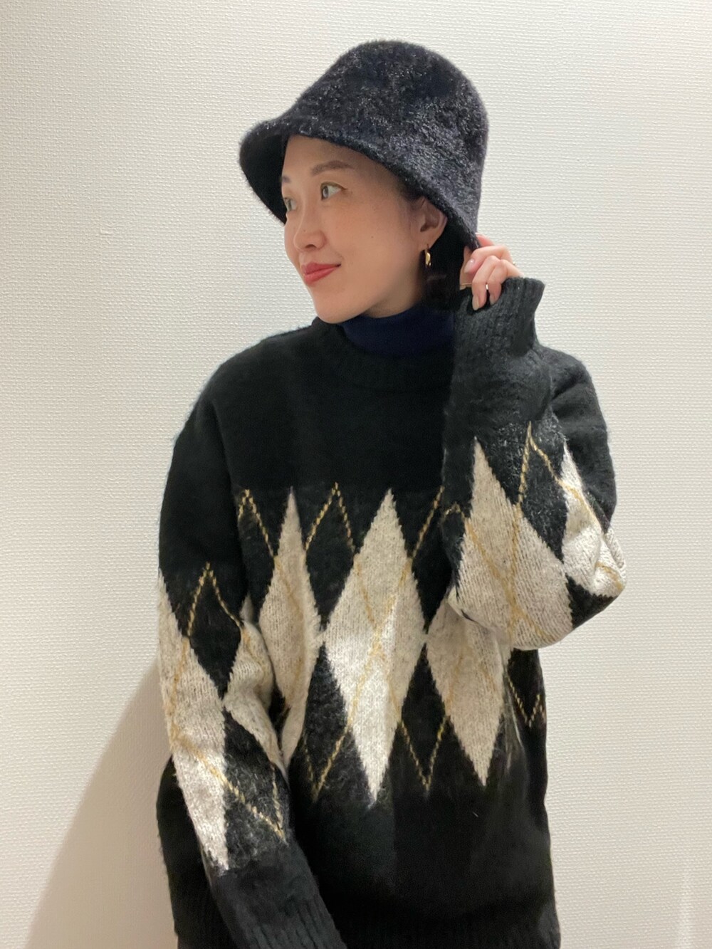 ブラック系のニット/セーター、グリーン系のニット/セーター、ブラック系のハットを着用したレディースの秋コーディネートの3枚目の写真