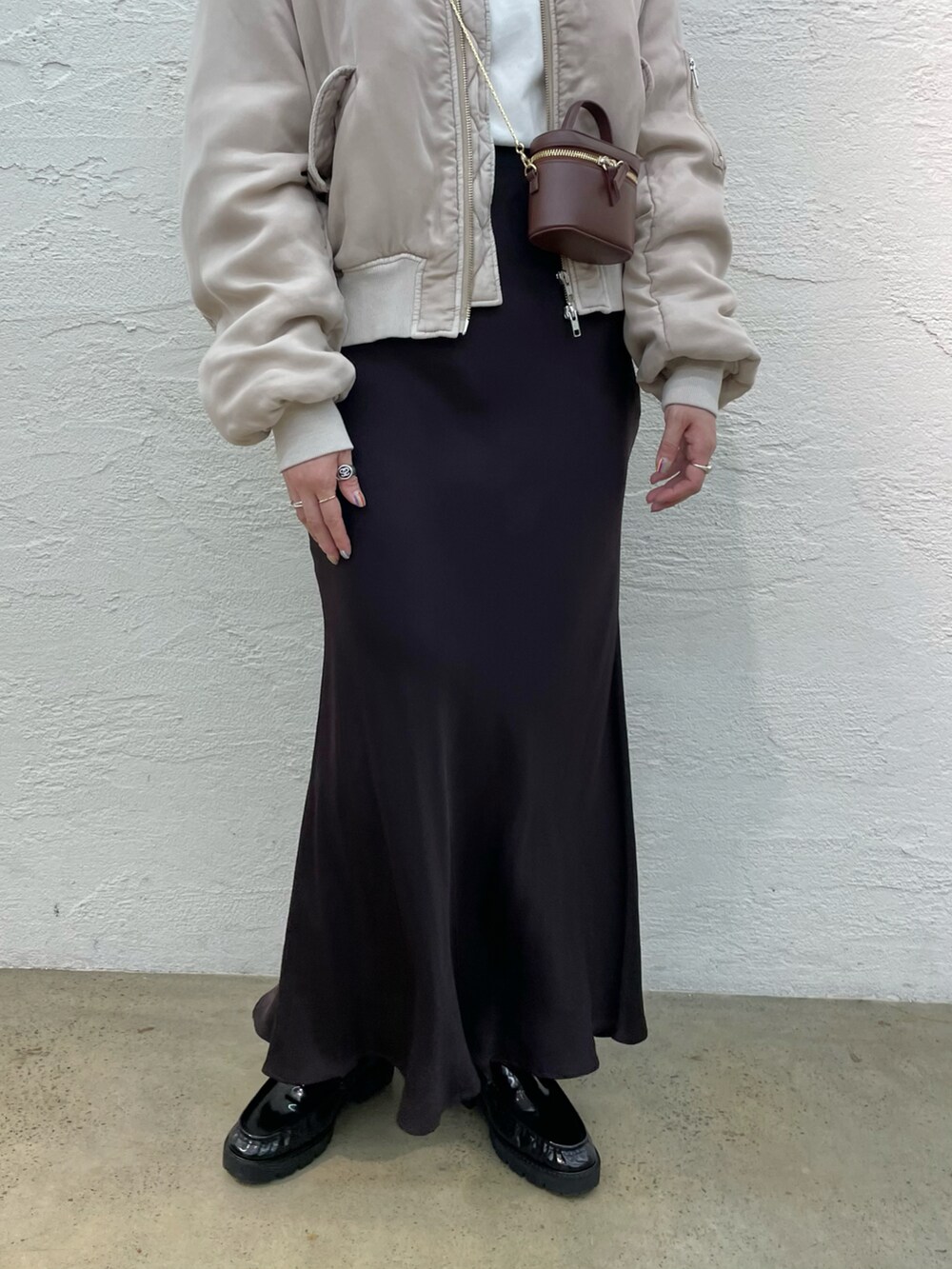 ブラック系のローファー、ブラウン系のスカート、ブラウン系のショルダーバッグを着用したレディースの夏コーディネートの5枚目の写真