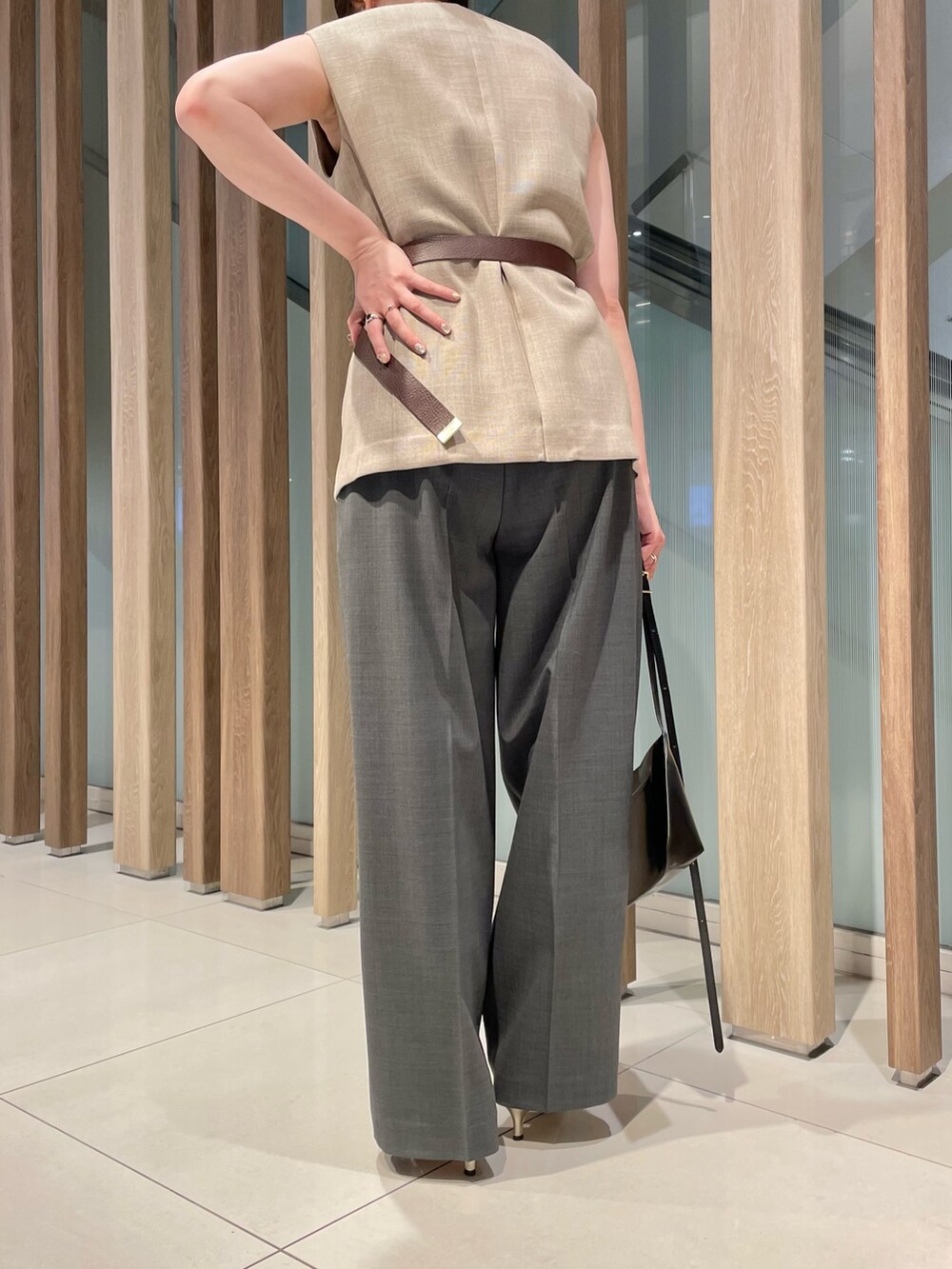 ベージュ系のベスト、ブラック系のショルダーバッグ、グレー系のスラックスを着用したレディースの春コーディネートの9枚目の写真