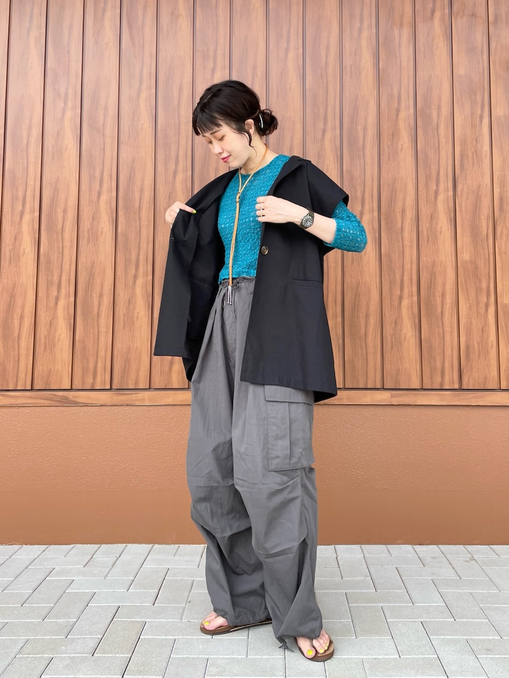 グレー系のカーゴパンツ、ブラウン系のサンダル、グリーン系のTシャツ/カットソーを着用したレディースの夏コーディネートの2枚目の写真