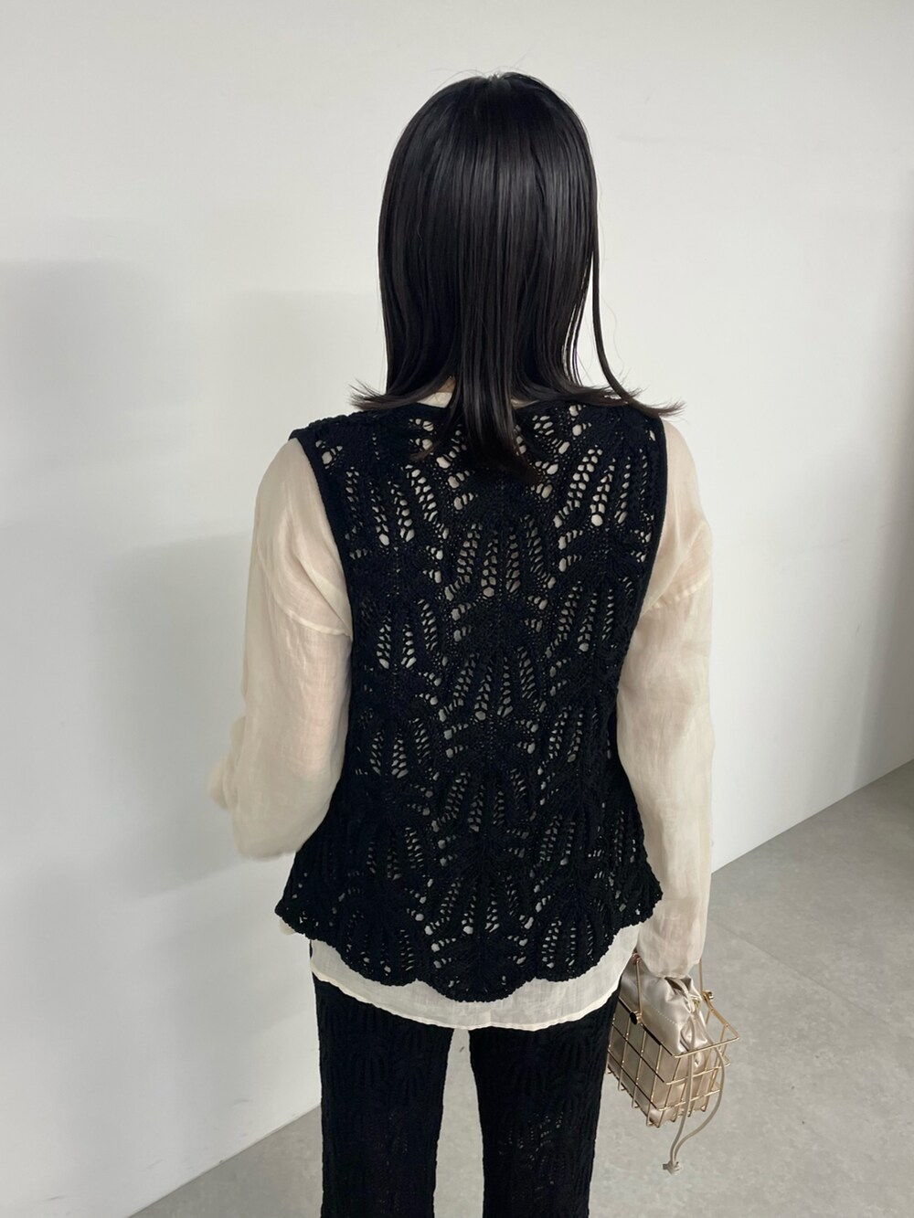 ブラック系のその他パンツ、ゴールド系のバッグ、ブラック系のベストを着用したレディースの春コーディネートの4枚目の写真