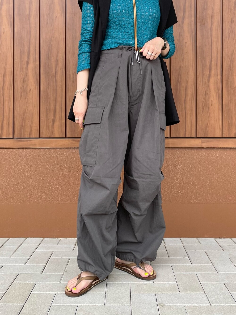 グレー系のカーゴパンツ、ブラウン系のサンダル、グリーン系のTシャツ/カットソーを着用したレディースの夏コーディネートの3枚目の写真