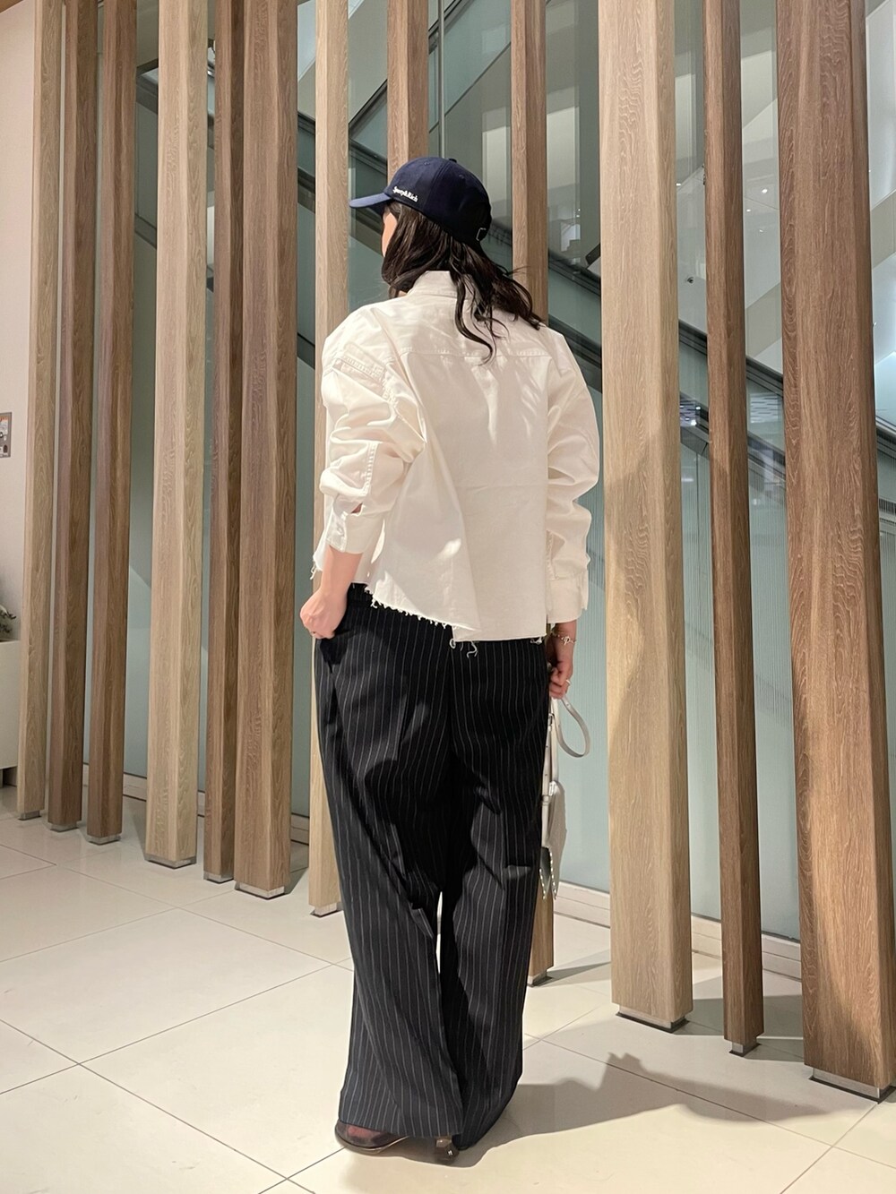 ブルー系のつなぎ/オールインワン、シルバー系のショルダーバッグ、ホワイト系のシャツ/ブラウスを着用したレディースの春コーディネートの2枚目の写真