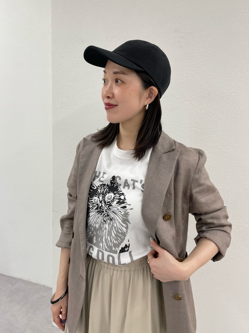 ホワイト系のTシャツ/カットソー、ベージュ系のテーラードジャケット、ベージュ系のスカートを着用したレディースの春コーディネートの3枚目の写真