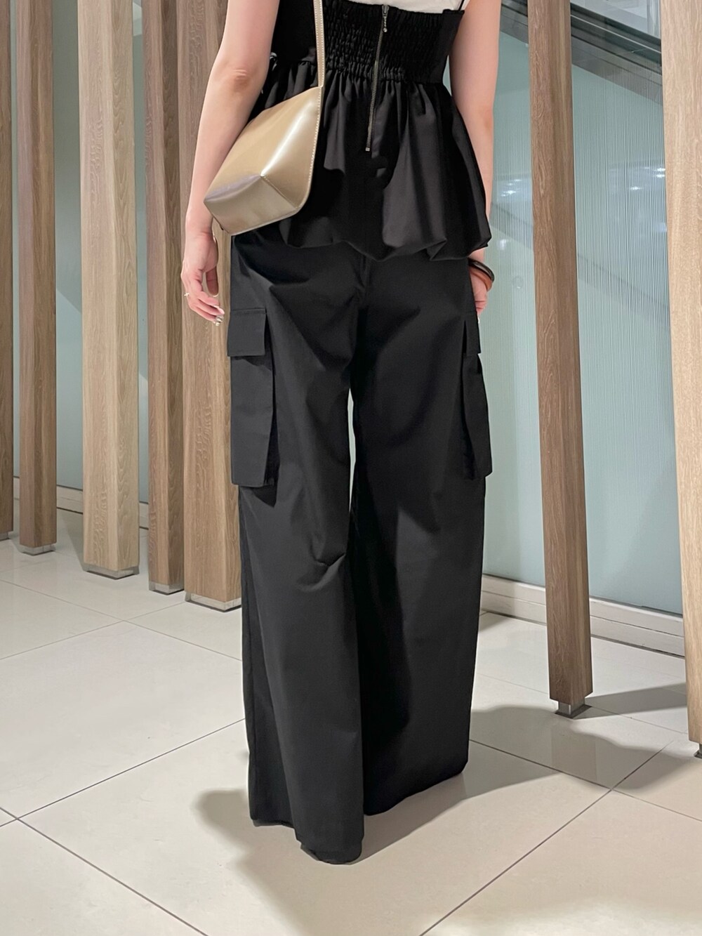 ブラック系のシャツ/ブラウス、ホワイト系のTシャツ/カットソー、ブラック系のカーゴパンツを着用したレディースの春コーディネートの9枚目の写真