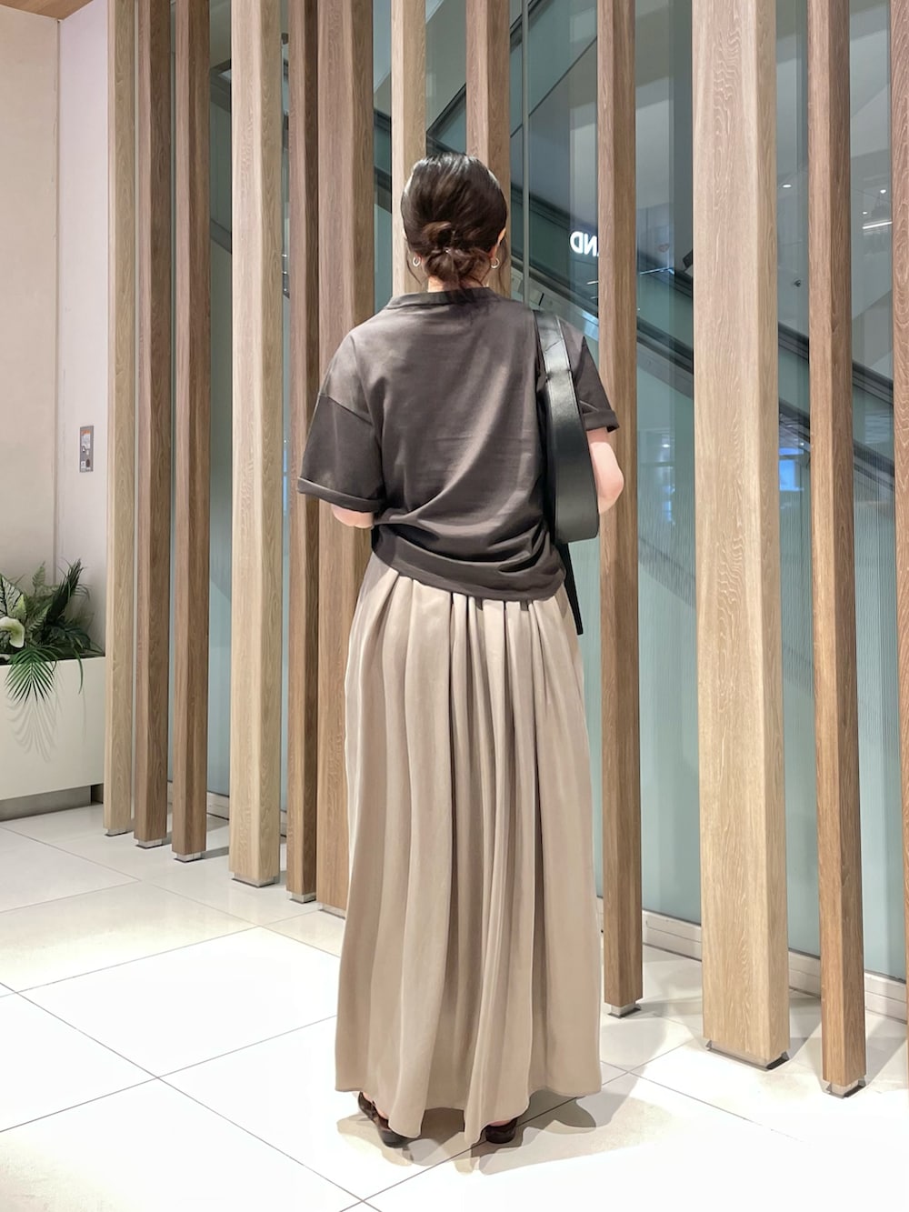 グレー系のTシャツ/カットソー、ベージュ系のワンピース、ブラウン系のサンダルを着用したレディースの夏コーディネートの2枚目の写真