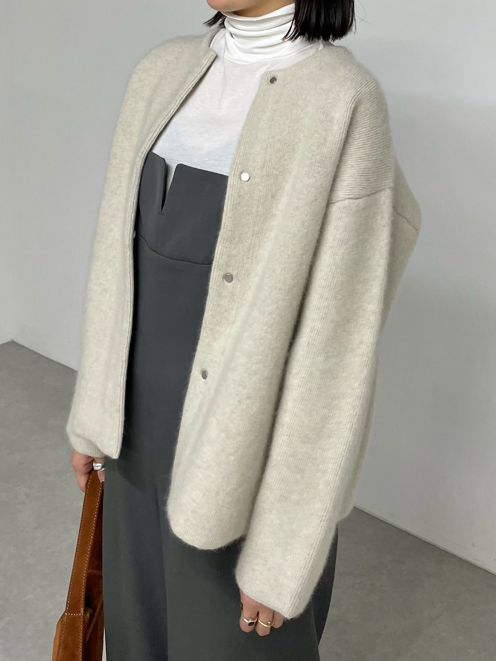 ベージュ系のノーカラージャケット、グレー系のサロペット/オーバーオール、ブラック系のブーツを着用したレディースの秋コーディネートの3枚目の写真