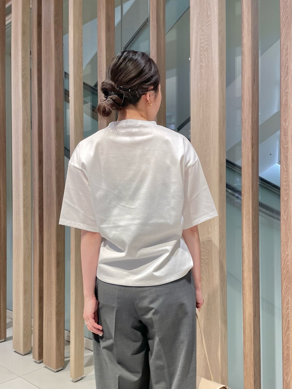 グレー系のスラックス、ベージュ系のハンドバッグ、ブラック系のサンダルを着用したレディースの春コーディネートの4枚目の写真