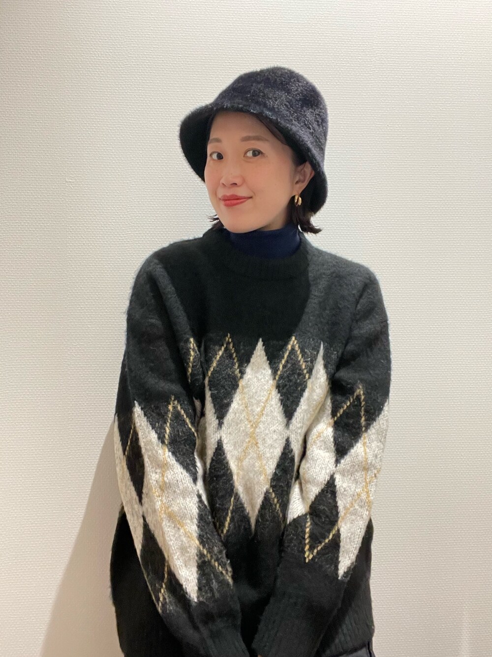 ブラック系のニット/セーター、グリーン系のニット/セーター、ブラック系のハットを着用したレディースの秋コーディネートの4枚目の写真