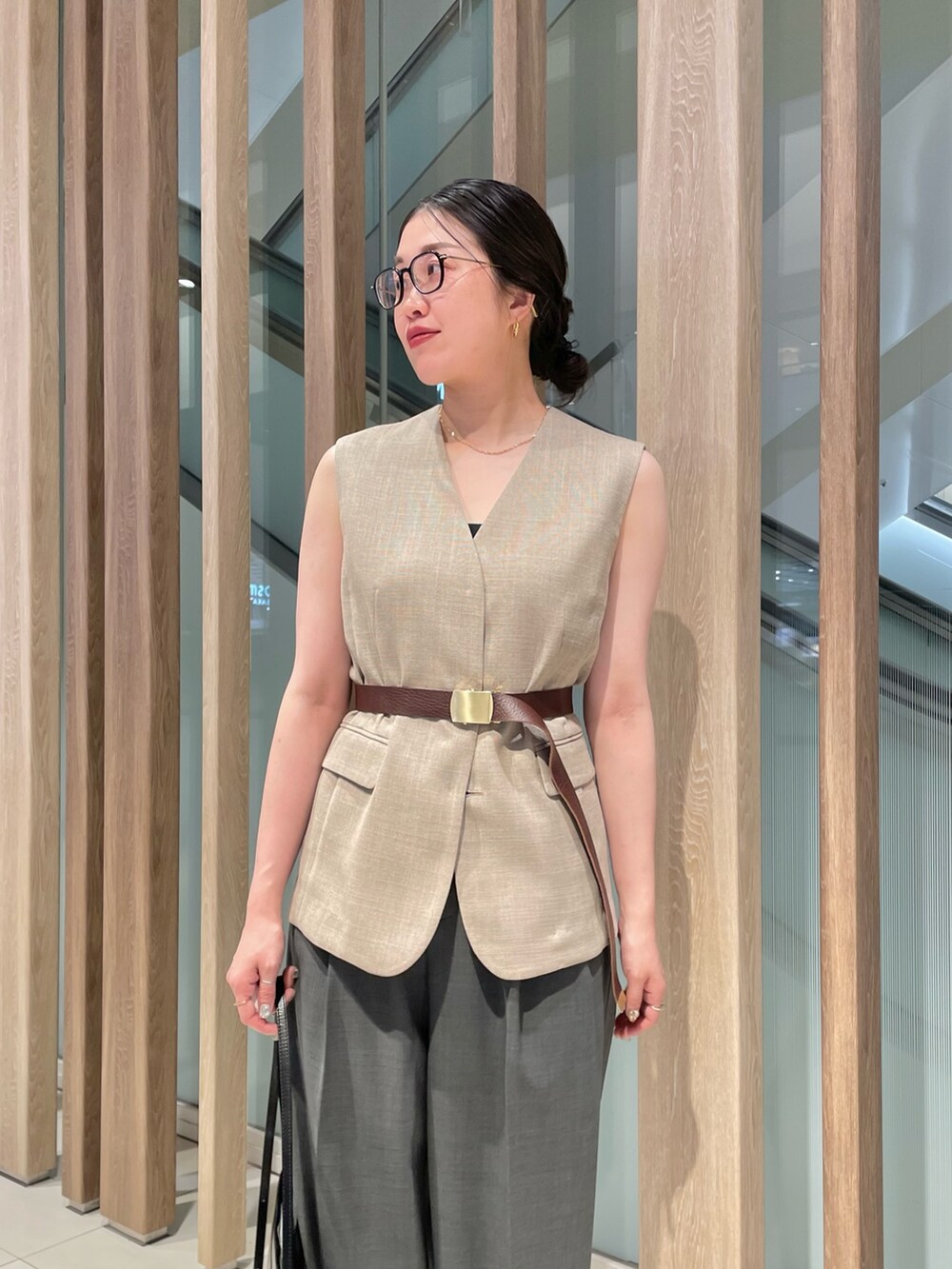 ベージュ系のベスト、ブラック系のショルダーバッグ、グレー系のスラックスを着用したレディースの春コーディネートの8枚目の写真