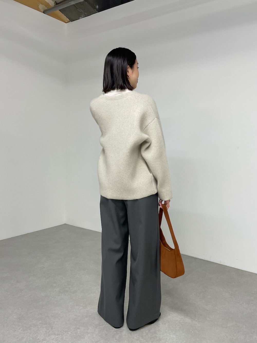 ベージュ系のノーカラージャケット、グレー系のサロペット/オーバーオール、ブラック系のブーツを着用したレディースの秋コーディネートの2枚目の写真