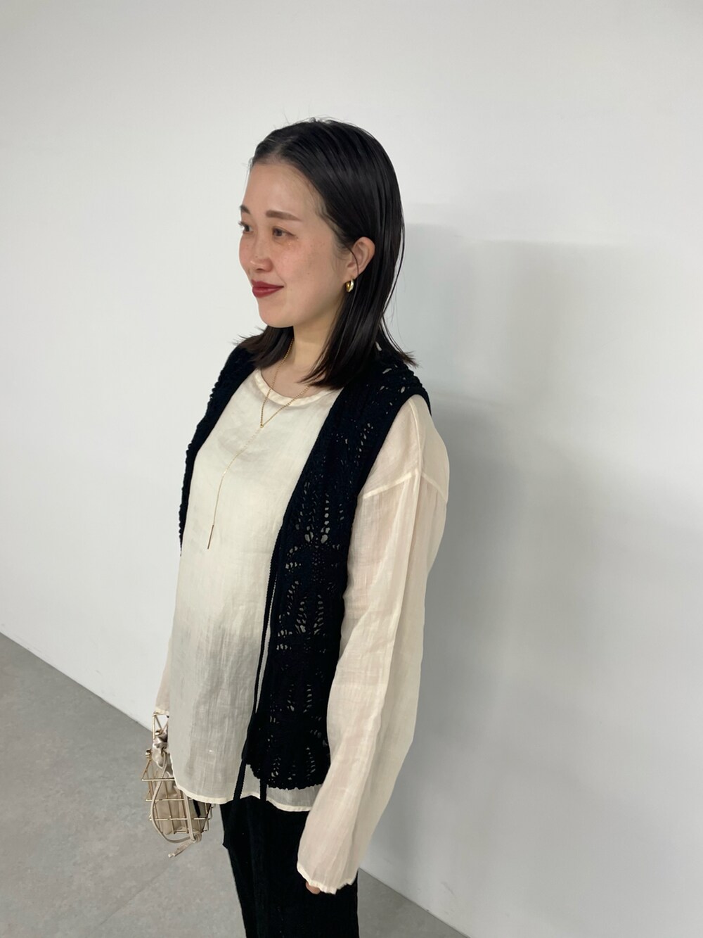 ブラック系のその他パンツ、ゴールド系のバッグ、ブラック系のベストを着用したレディースの春コーディネートの3枚目の写真