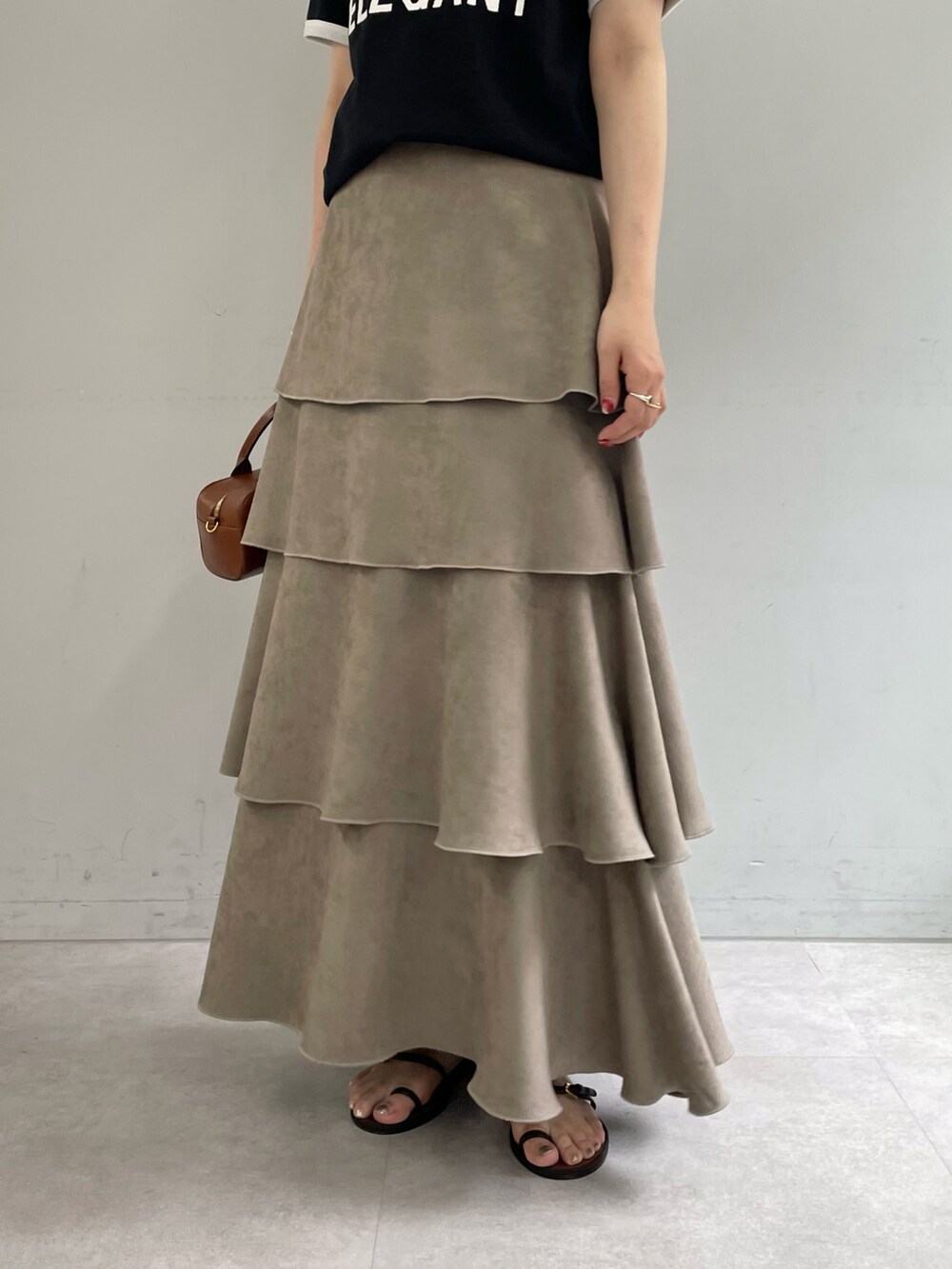 ブラック系のTシャツ/カットソー、ベージュ系のスカート、ゴールド系のブレスレットを着用したレディースの夏コーディネートの4枚目の写真