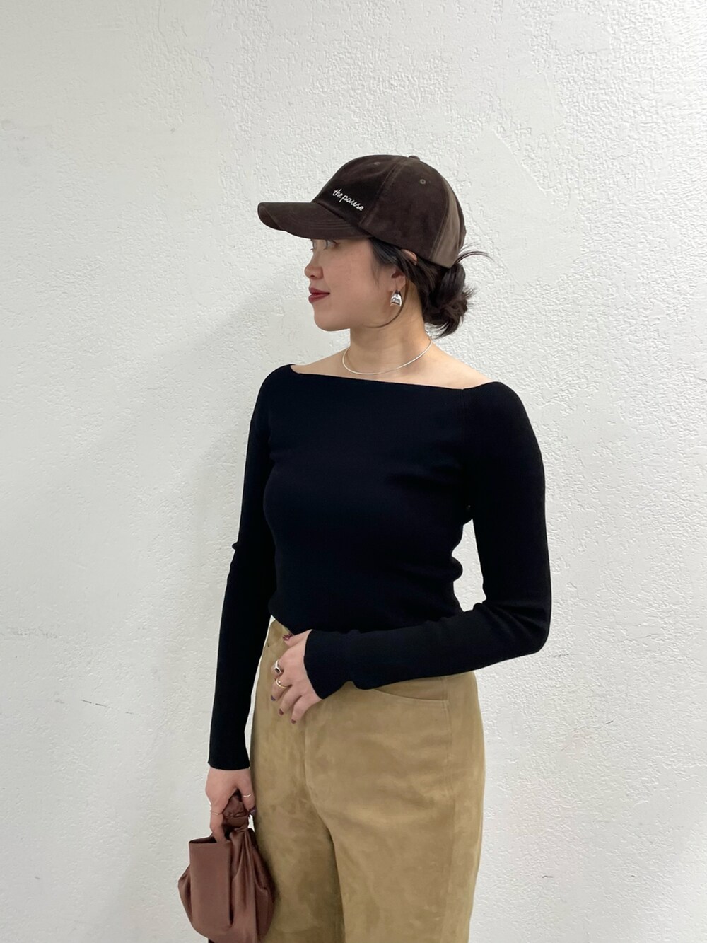 イエロー系のパンプス、イエロー系のパンツ、ブラウン系のハンドバッグを着用したレディースの冬コーディネートの3枚目の写真