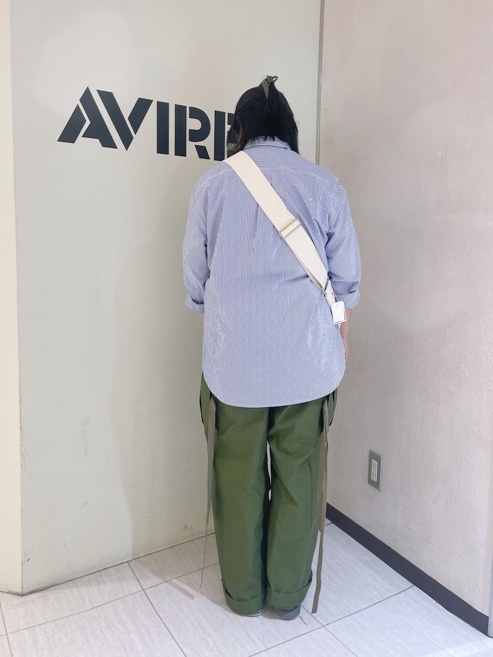 グリーン系のカーゴパンツ、ブルー系のシャツ/ブラウス、ホワイト系のショルダーバッグを着用したレディースの春コーディネートの3枚目の写真