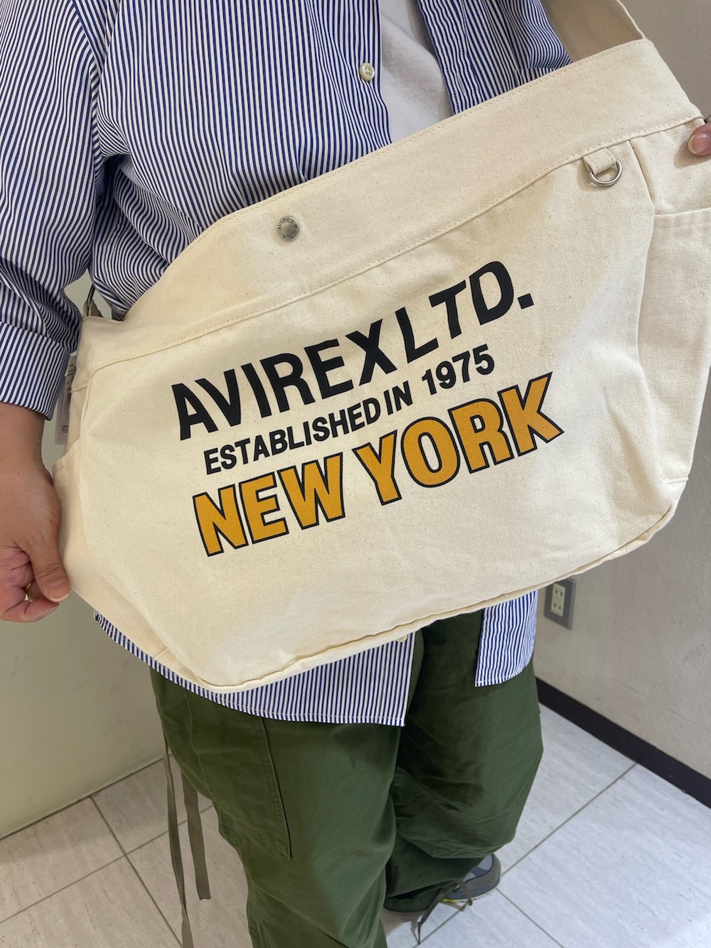 グリーン系のカーゴパンツ、ブルー系のシャツ/ブラウス、ホワイト系のショルダーバッグを着用したレディースの春コーディネートの4枚目の写真