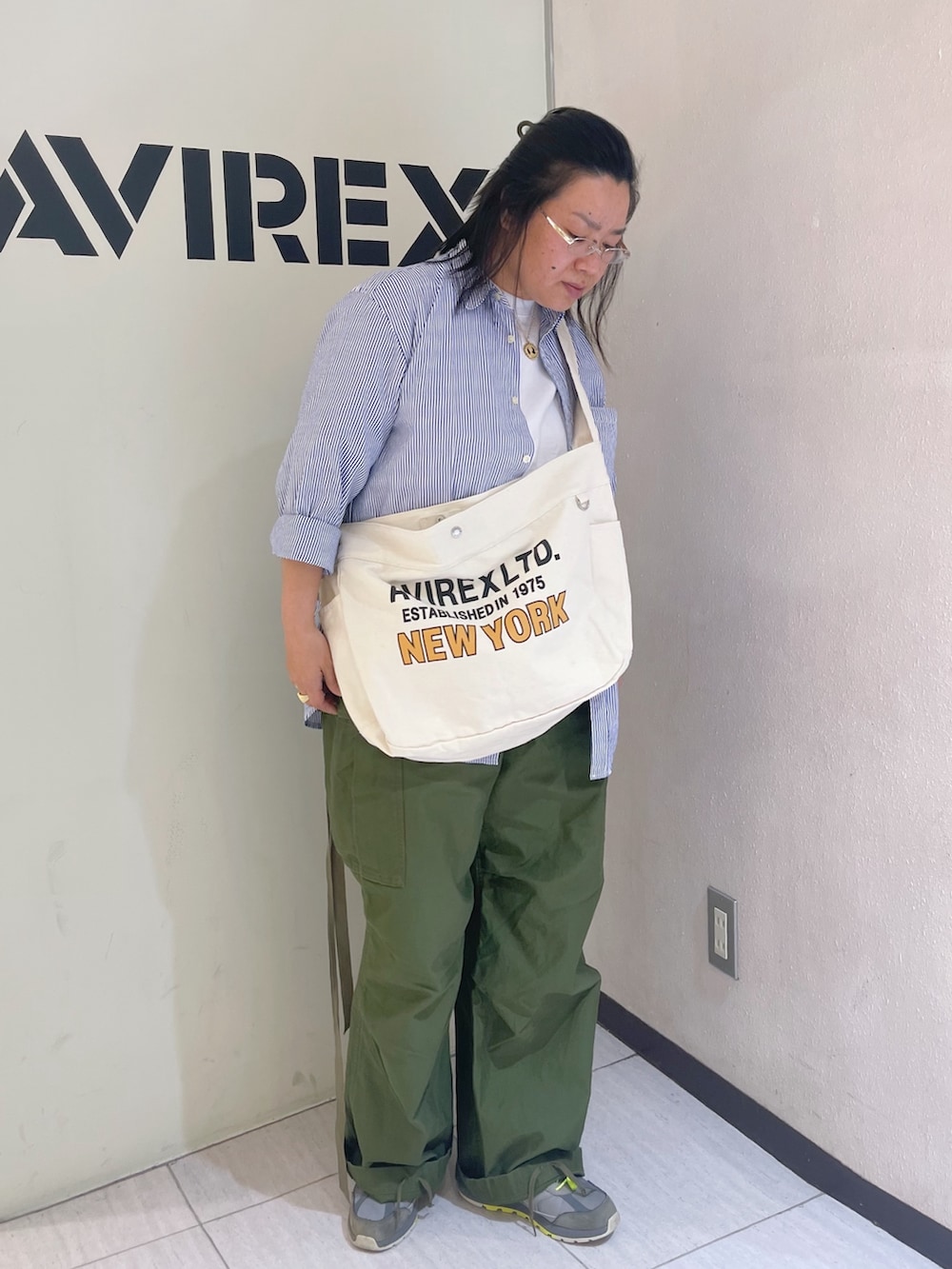 グリーン系のカーゴパンツ、ブルー系のシャツ/ブラウス、ホワイト系のショルダーバッグを着用したレディースの春コーディネートの2枚目の写真