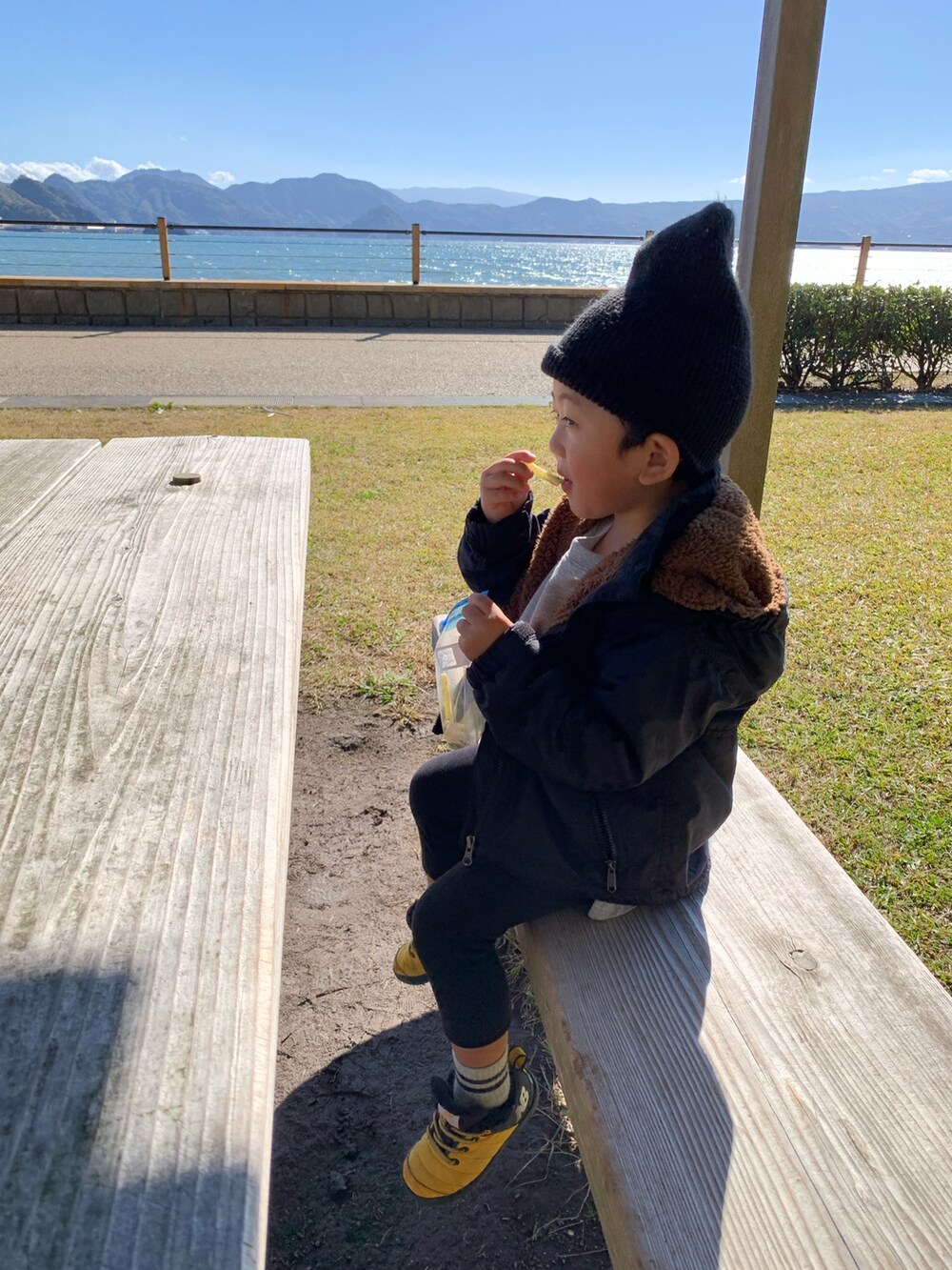 イエロー系のスニーカー、グレー系のTシャツ/カットソー、ブラック系のナイロンジャケットを着用したキッズの秋コーディネートの3枚目の写真