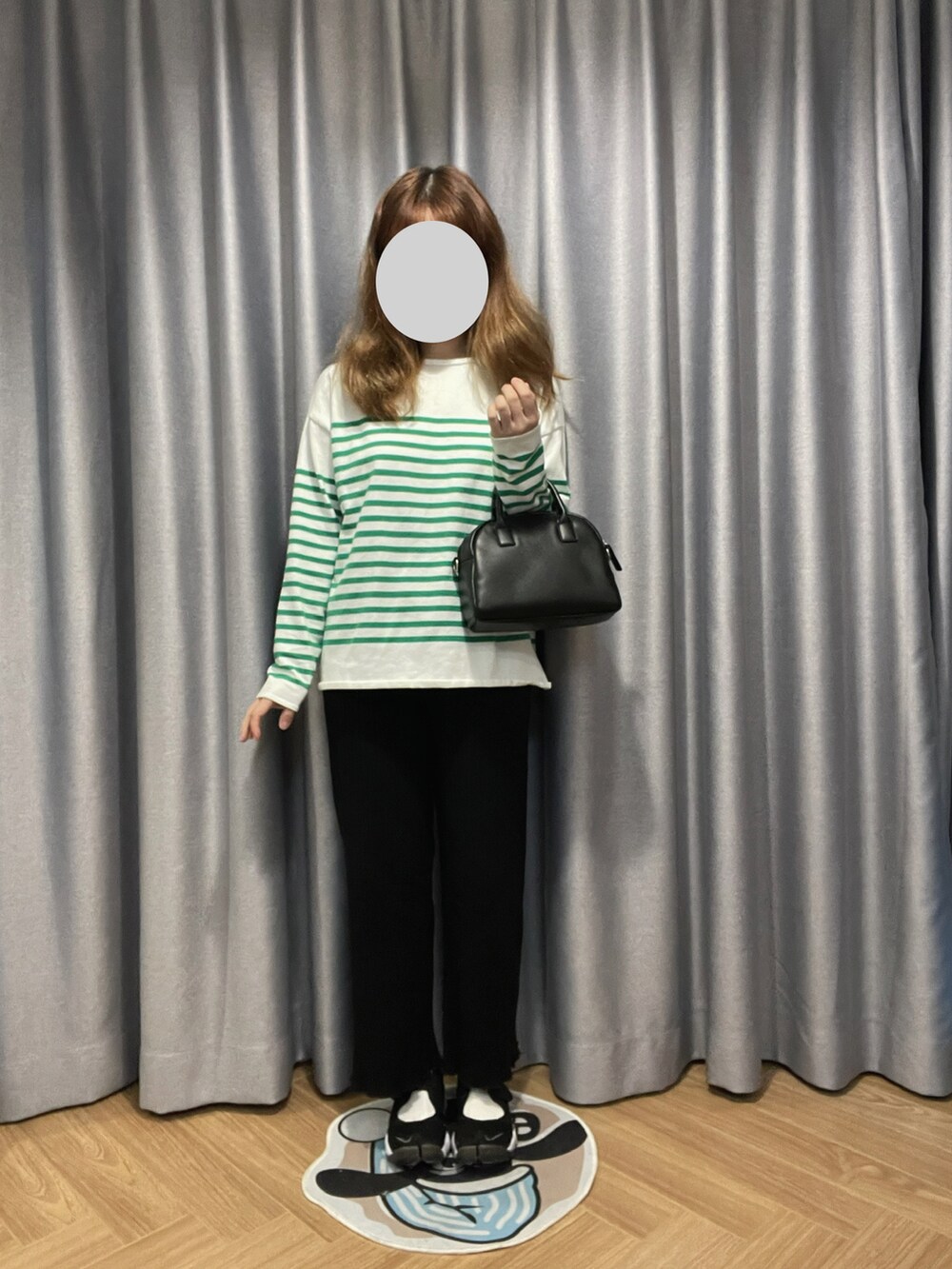 ホワイト系のボストンバッグ、グリーン系のトップス、ブラック系のスニーカーを着用したレディースの冬コーディネートの2枚目の写真