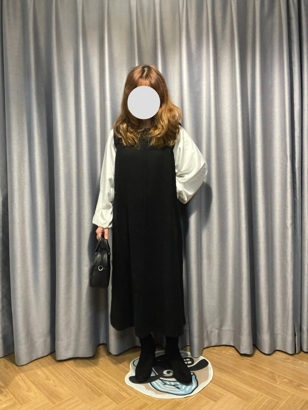 ブラック系のワンピース、ホワイト系のボストンバッグを着用したレディースの冬コーディネートの2枚目の写真