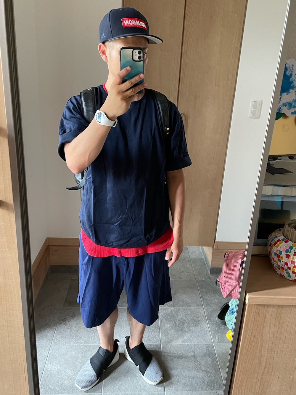 ホワイト系のスリッポン、ブラック系のバックパック/リュック、ホワイト系のアナログ腕時計を着用したメンズの夏コーディネートの2枚目の写真