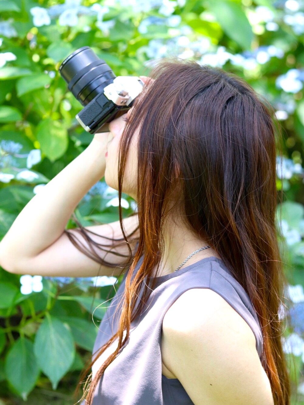 グレー系のトップス、ブラック系のスカート、ブラック系のパンプスを着用したレディースの夏コーディネートの3枚目の写真