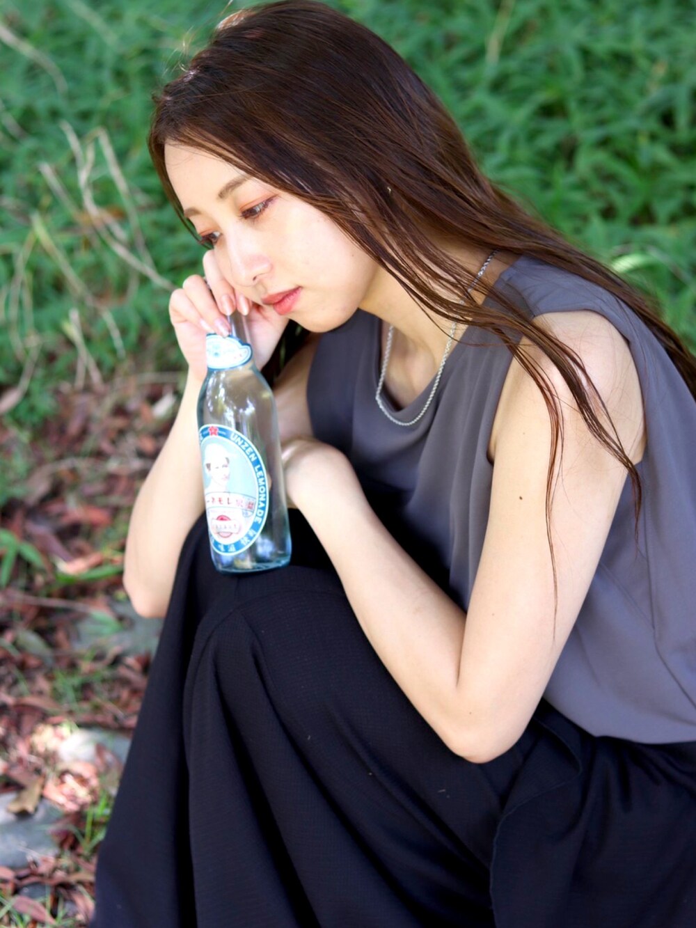 グレー系のトップス、ブラック系のスカート、ブラック系のパンプスを着用したレディースの夏コーディネートの2枚目の写真