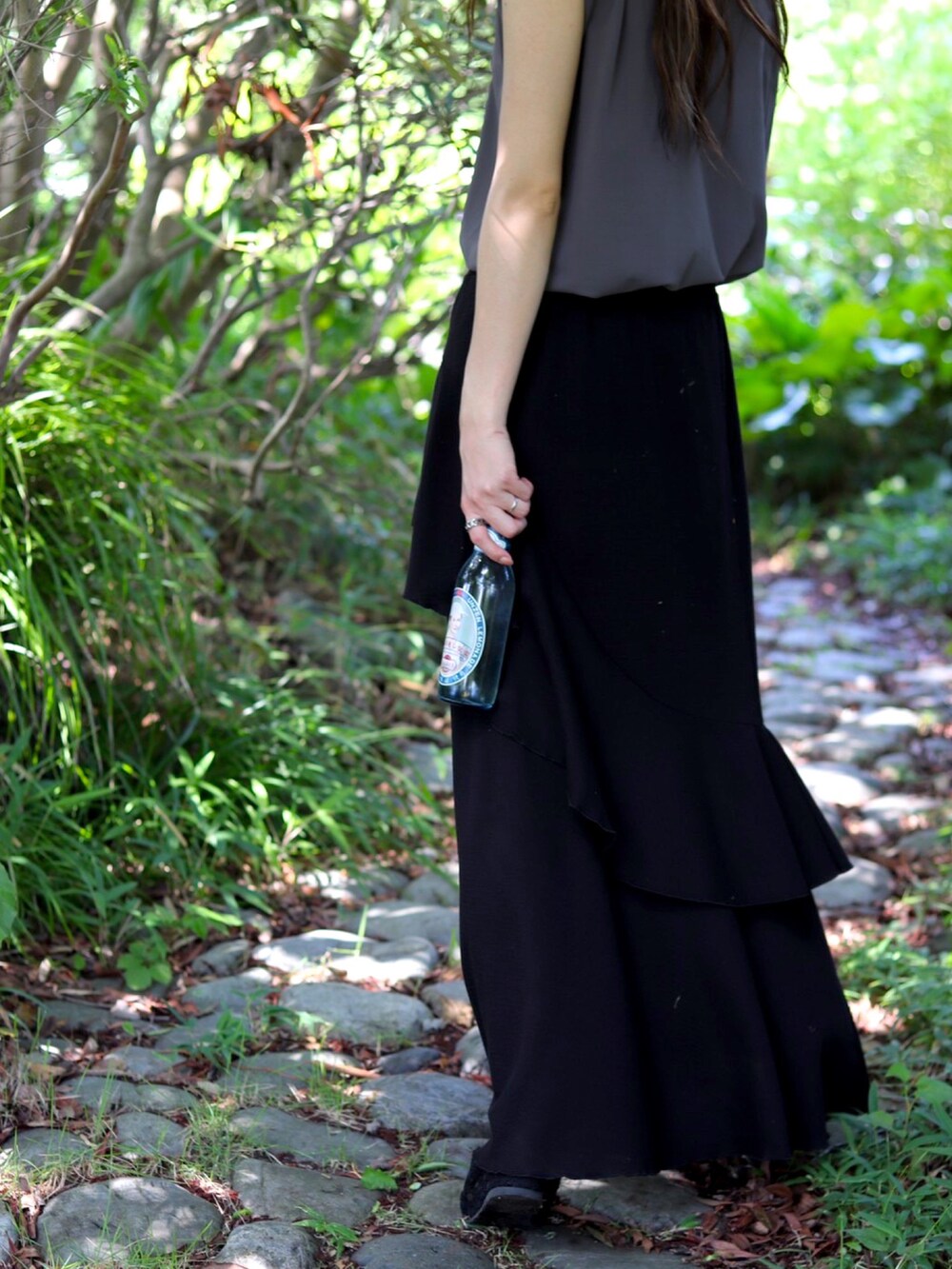 グレー系のトップス、ブラック系のスカート、ブラック系のパンプスを着用したレディースの夏コーディネートの4枚目の写真