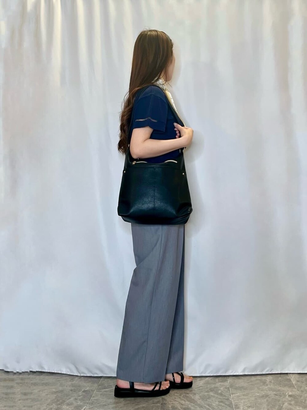 ブルー系のニット/セーター、グレー系のその他パンツ、ブラック系のサンダルを着用したレディースの夏コーディネートの2枚目の写真