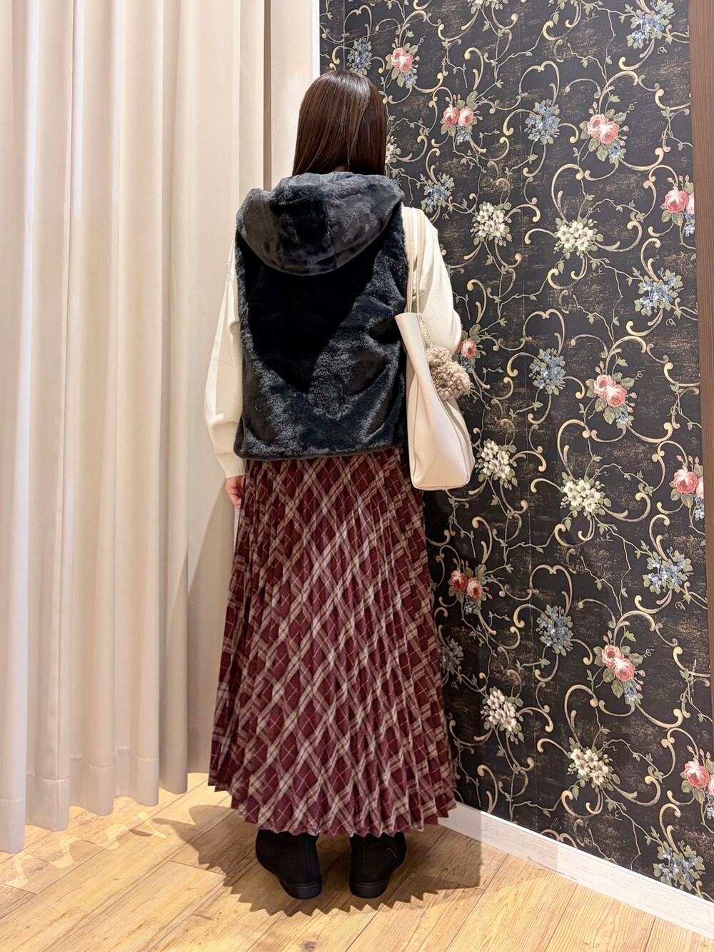ブラック系のブルゾン、ホワイト系のニット/セーター、ブラック系のブーツを着用したレディースの秋コーディネートの5枚目の写真