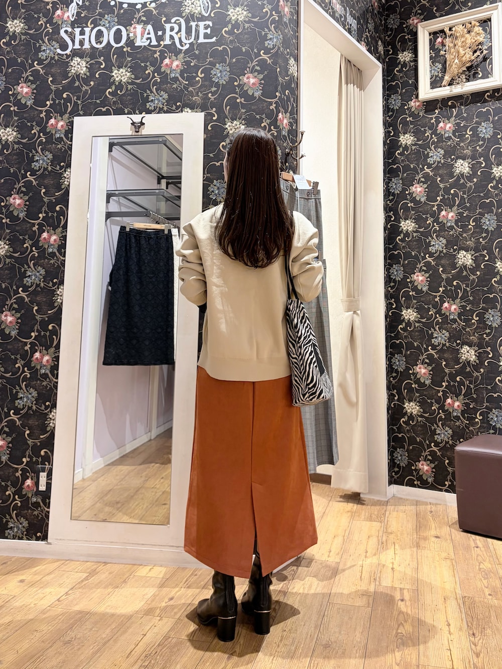 ベージュ系のカーディガン/ボレロ、ブラック系のTシャツ/カットソー、レッド系のスカートを着用したレディースの秋コーディネートの5枚目の写真